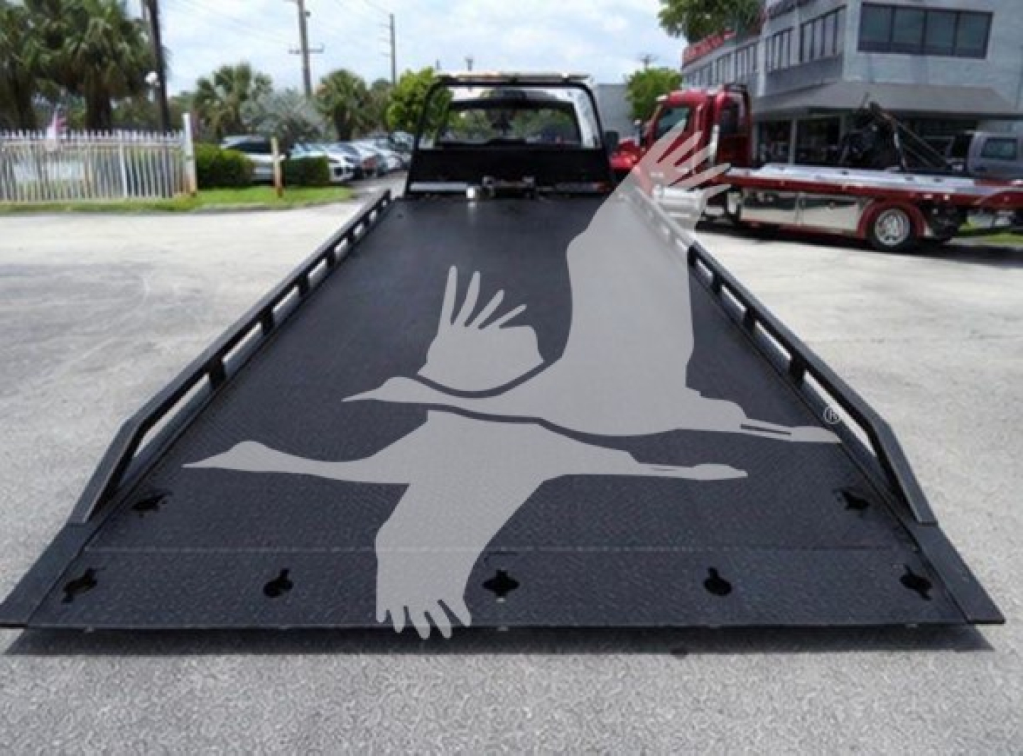 Ram 2021 Slt roll-back truck bed with graphic of flying birds on ramp surface, rear view
