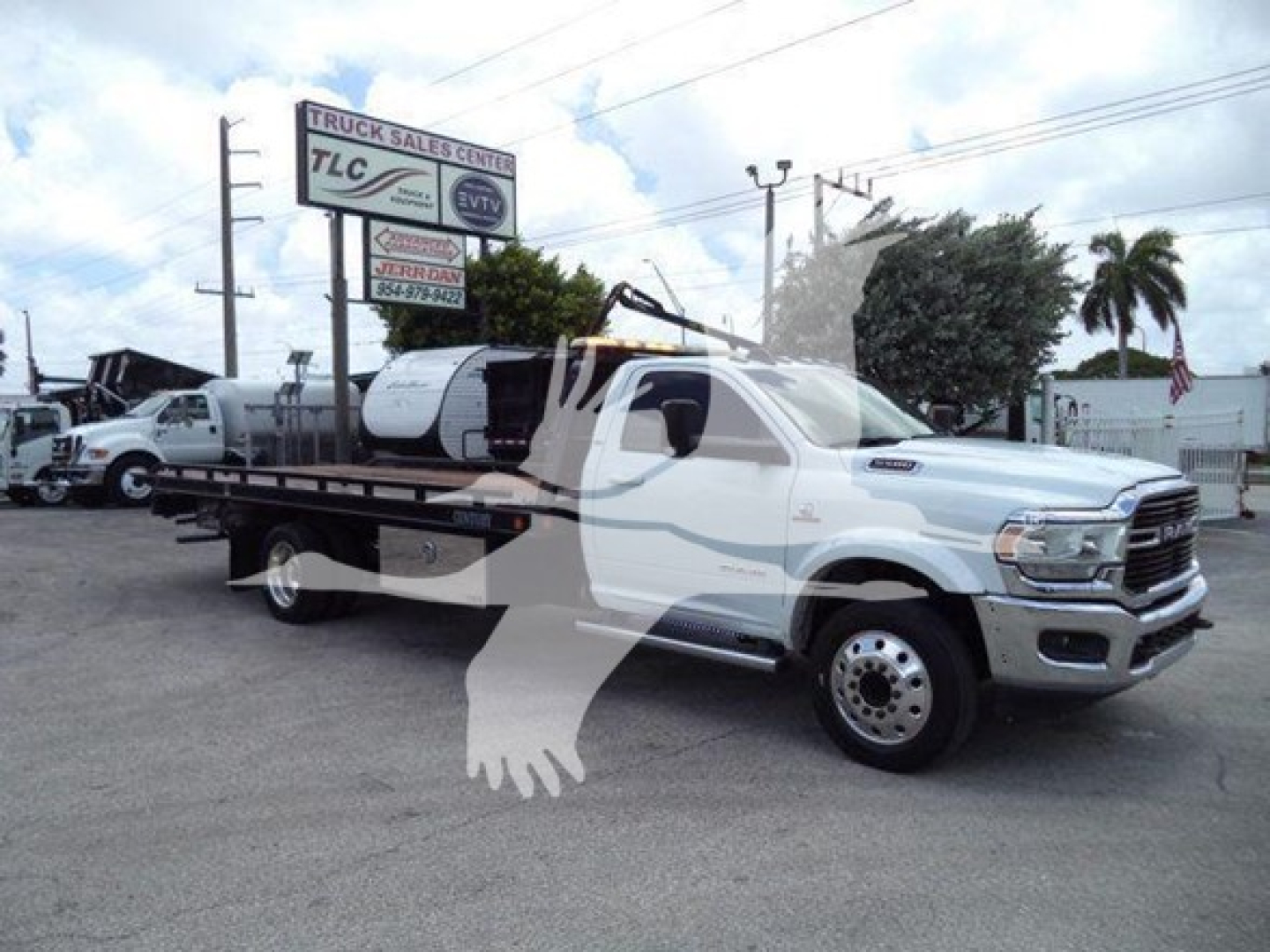 Ram 3500 rollback truck with extended flatbed and crane, white cab, dealership sign in background, VIN tag not visible, stock T25888.