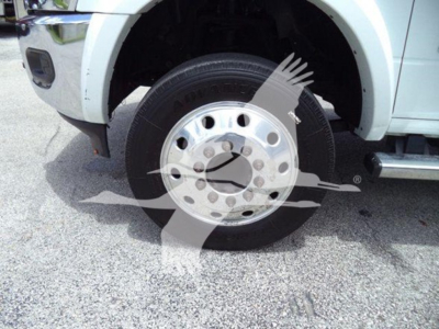 Truck front wheel and fender with steel wheel and tire visible in a roll-back truck. VIN and stock not pictured, wheel close-up.