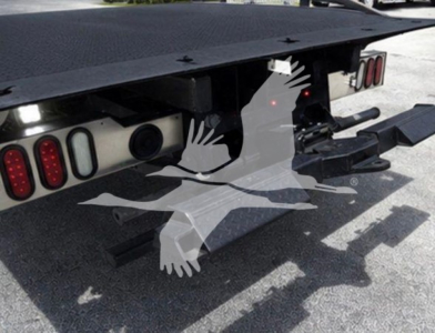 Rear view of a Ram rollback truck showing taillights, hitch, and flatbed with support beams.