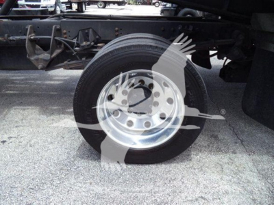 Wheel and front suspension under a Ram Slt rollback truck with shiny alloy wheel and tire, part of undercarriage visible.