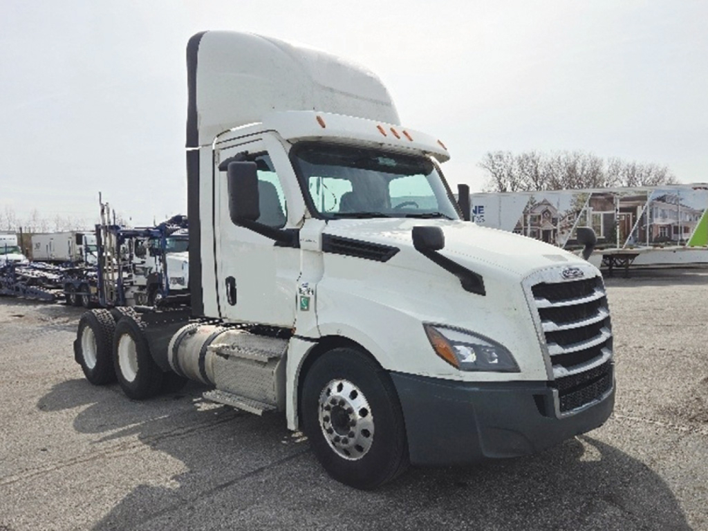 White Freightliner Cascadia125/126 sleeper cab truck with diesel fuel tanks, showing front grille and side view. Visible text not legible.