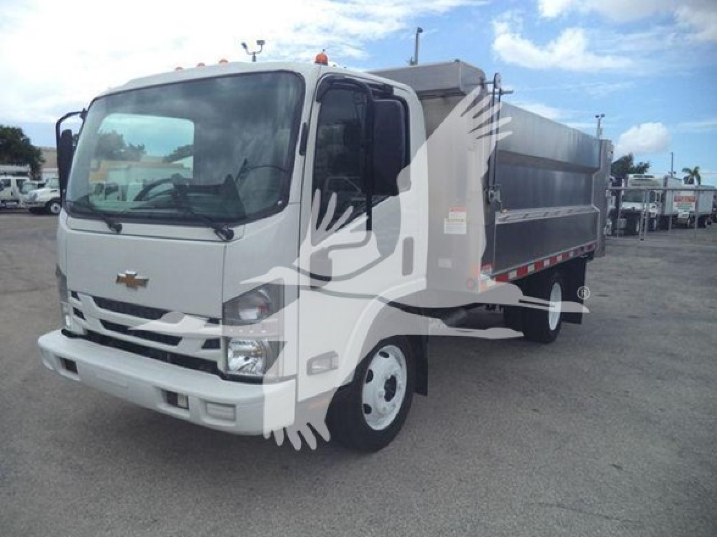 Dump truck with white cab and gray dump body, Chevrolet logo on grille, front view angled to right.