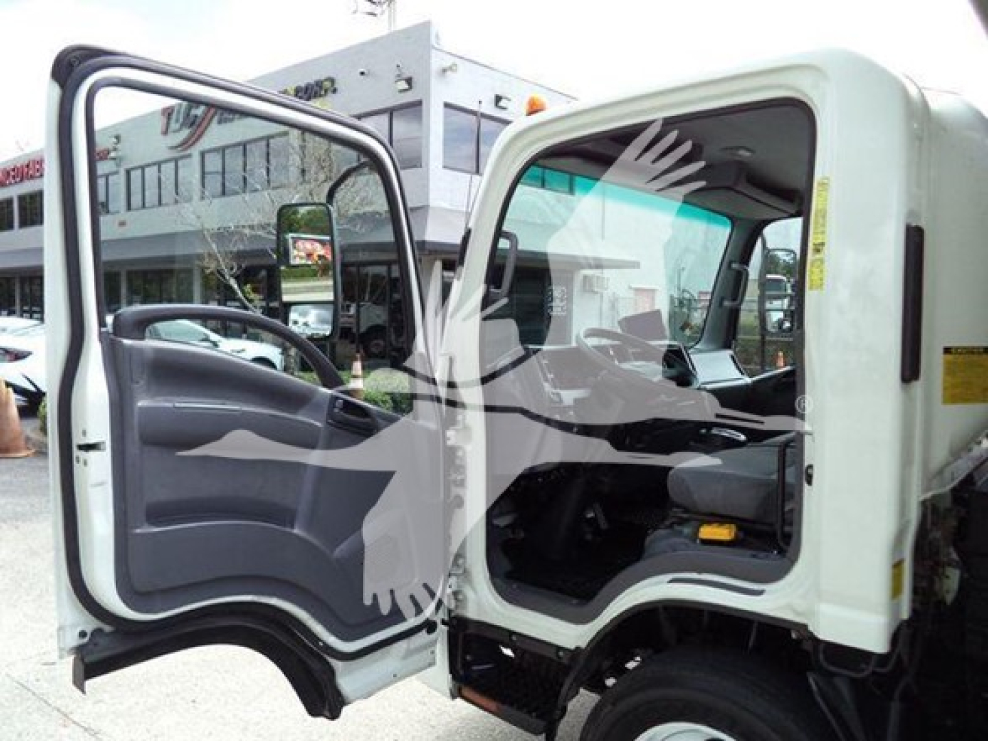 Chevrolet W4500 cab interior and open door showing steering wheel and dashboard of a white dump truck.