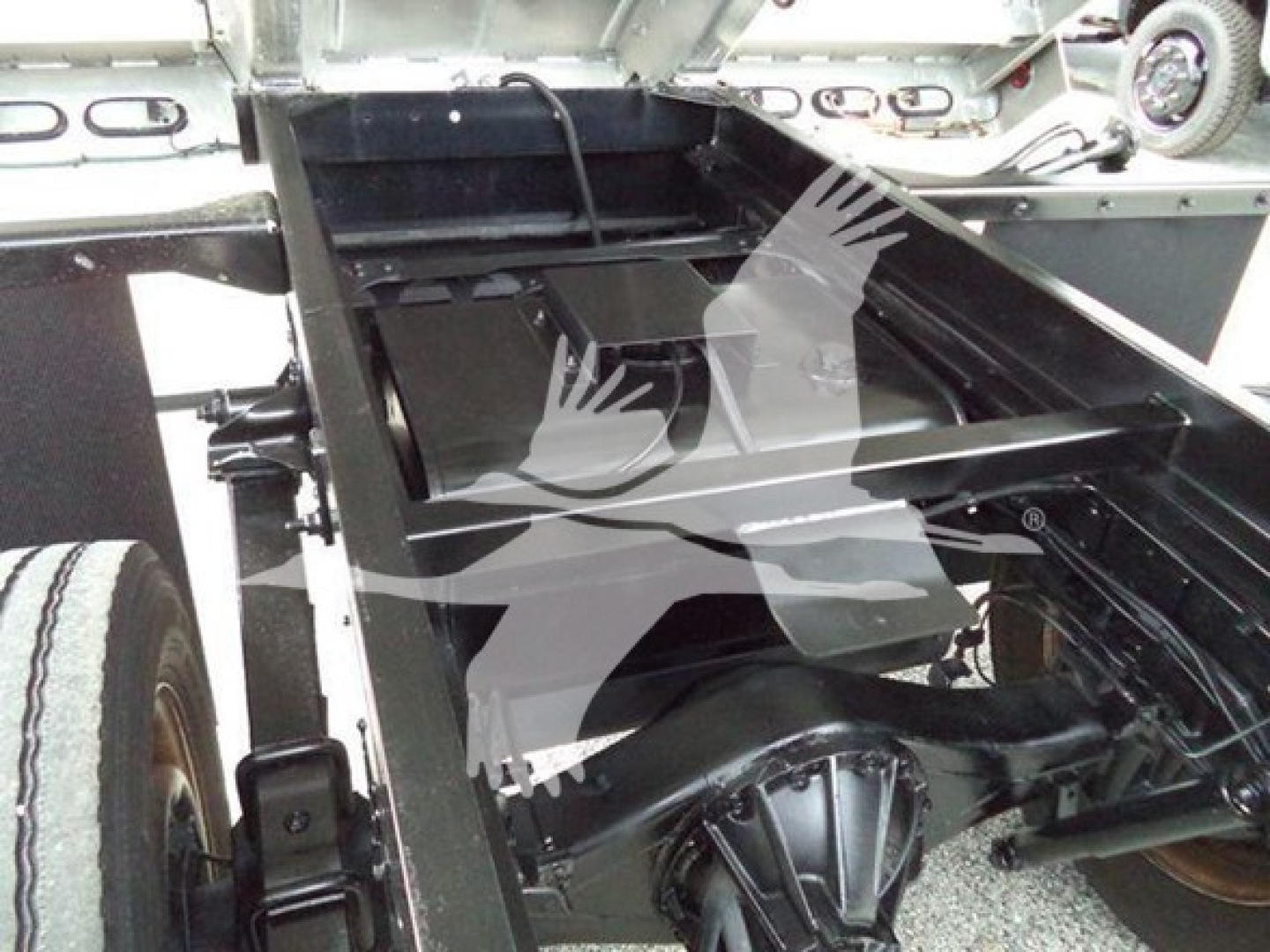 Truck chassis and dump bed area showing frame rails and rear suspension under a 2017 Chevrolet W4500 dump truck.