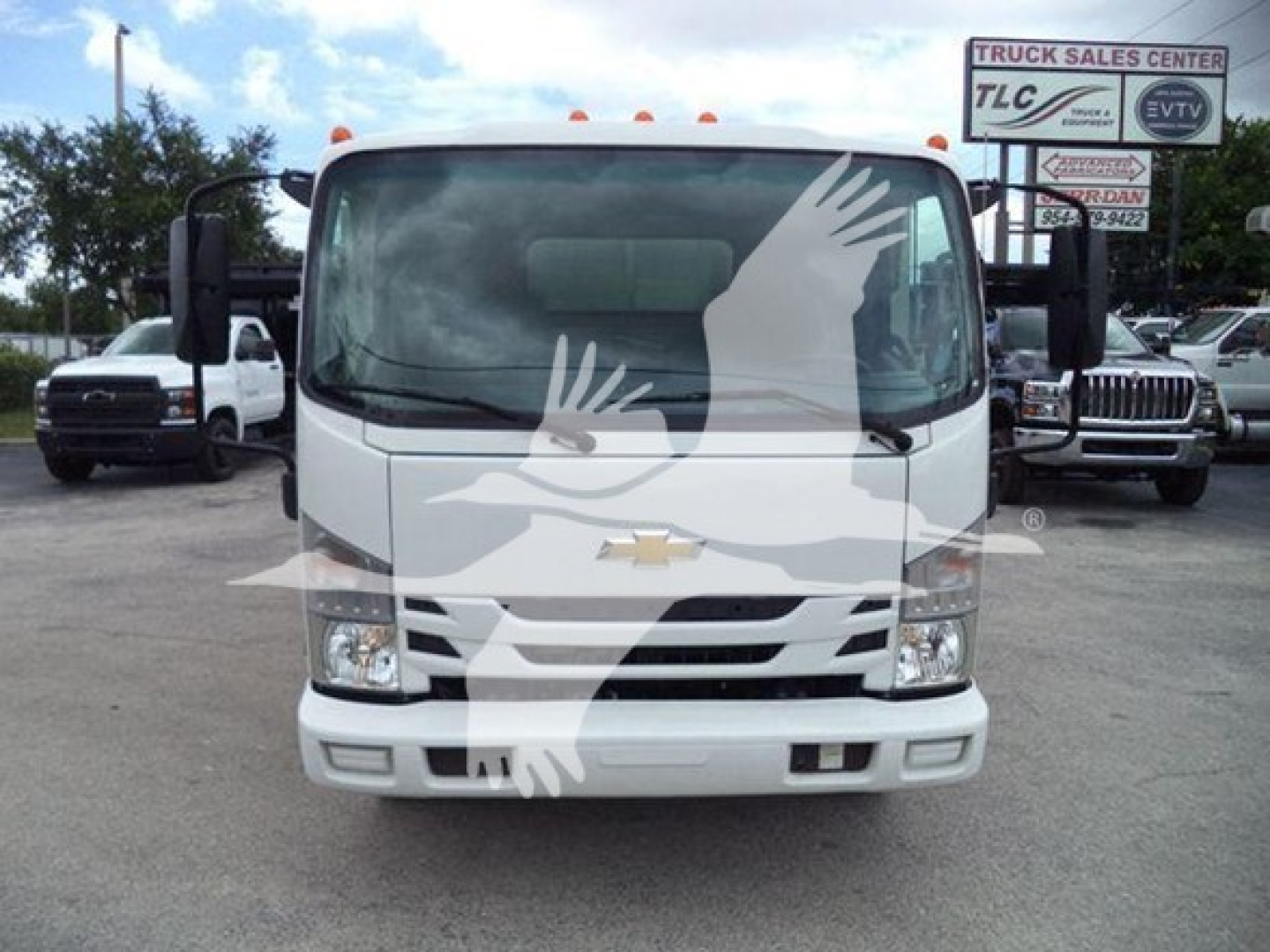 Front view of a white 2017 Chevrolet W4500 dump truck with large windshield, Chevrolet logo on grille, and side mirrors visible; dealership lot in background.