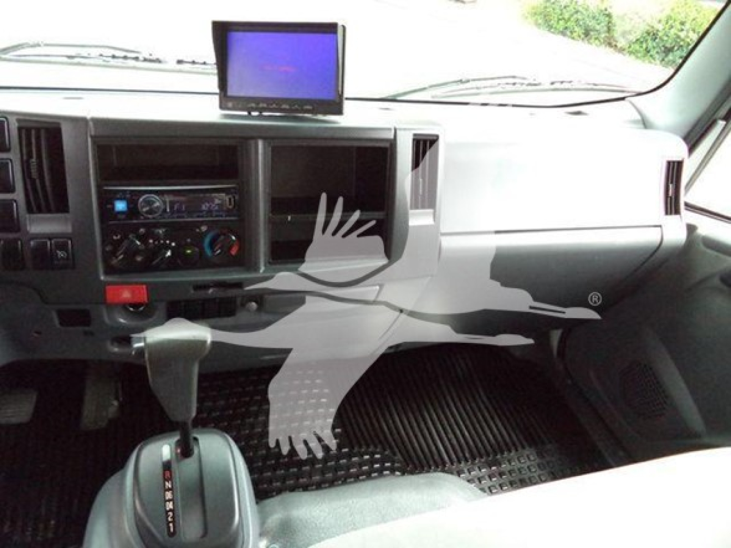 Vehicle interior showing dashboard with center stack, gear shifter, and a mounted screen in a 2017 Chevrolet W4500 dump truck.