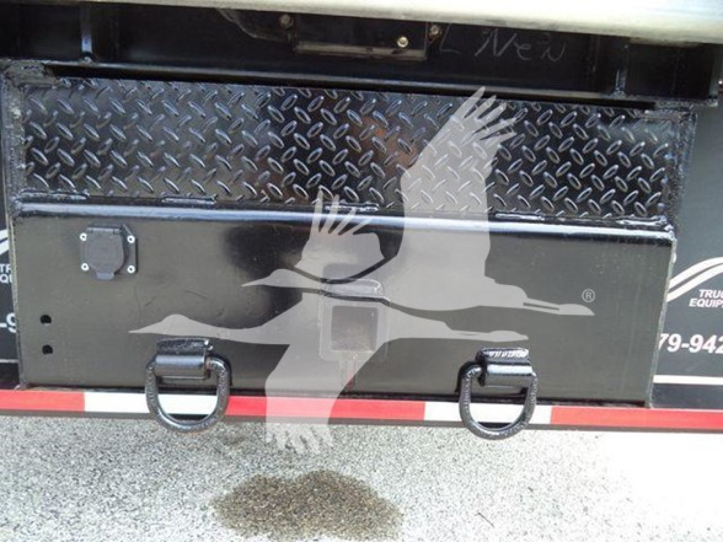 Chevrolet W4500 dump truck tailgate area with diamond plate toolbox and D-ring latches.