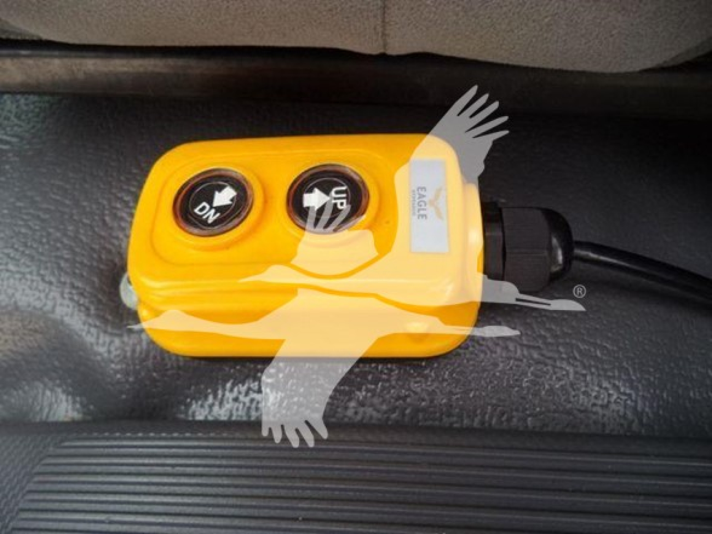 Switch panel with two black circular buttons labeled 'ON' and 'UP' on a yellow housing, connected by a black cable.