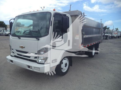 Dump truck with white cab and gray dump body, Chevrolet logo on grille, front view angled to right.