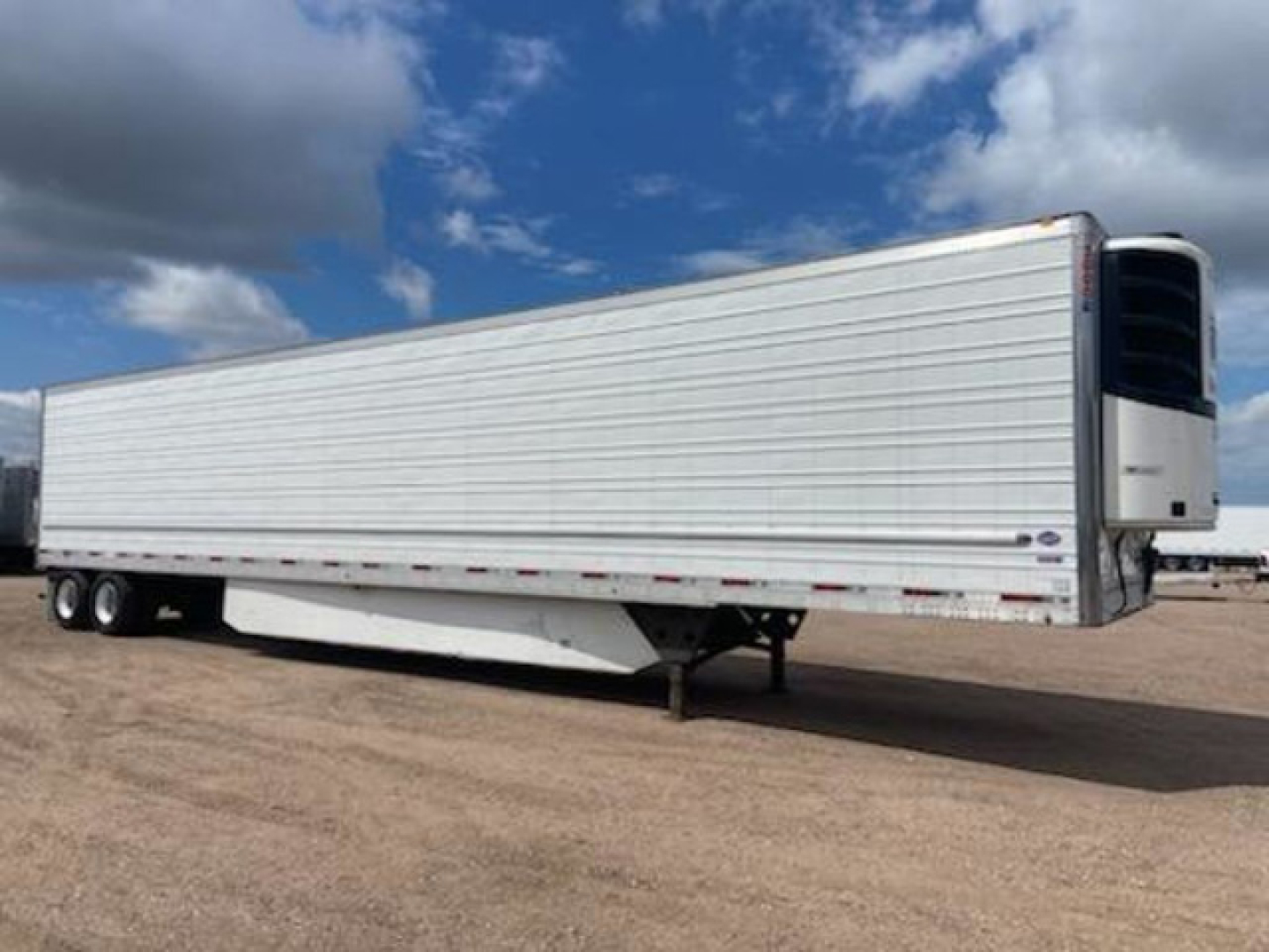 Reefer trailer from 2020 Utility with side view, closed aluminum siding, rear refrigeration unit, tandem axles, and landing gear visible.