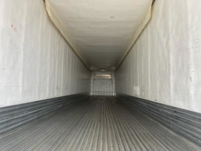 Trailer interior showing empty refrigerated trailer cargo area with ribbed metal floor and white side walls.