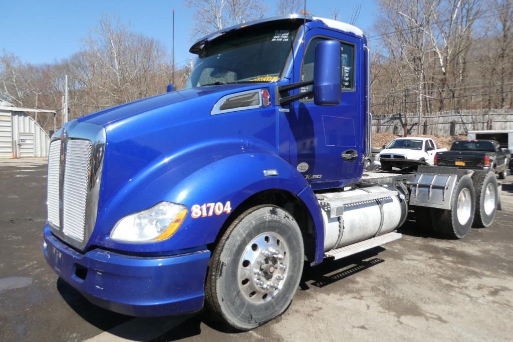 Kenworth T680 tractor in blue front-left view showing cab, grille, fuel tank, and dual rear axles. 2015 model with VIN 1XKYDP9X1FJ460498 and stock 1124251.