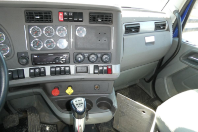 Kenworth T680 dashboard with multiple gauges, climate controls, and gear shifter in view.