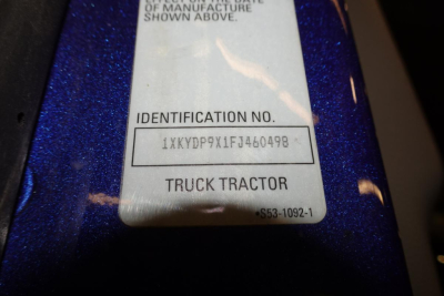 Kenworth T680 identification label showing VIN 1XKYDP9X1FJ460498 and stock number area on blue chassis.