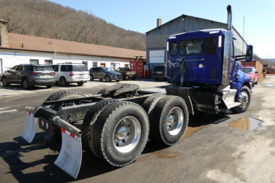 Kenworth T680 semi truck chassis with three axles and dual rear wheels, blue cab, visible VIN/stock information area not shown.