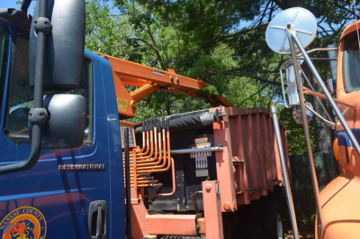 Truck cab with orange loader crane and shredder bed visible in bed of a blue International DuraStar 4300 loader dump truck.