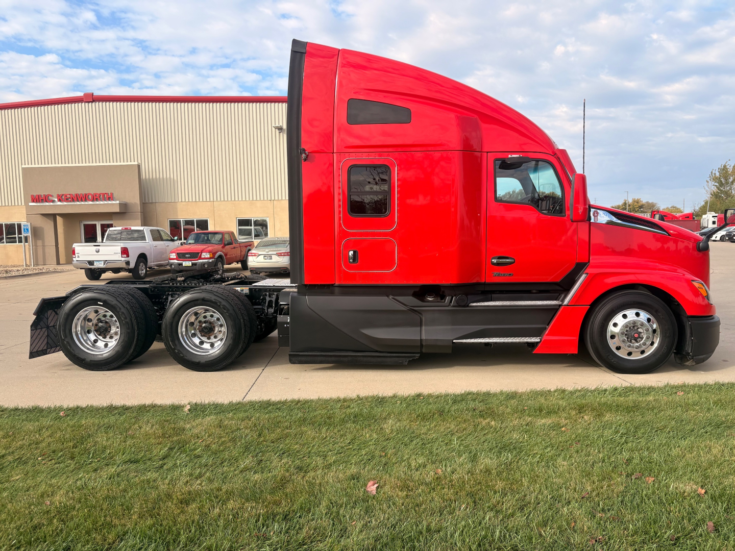 Kenworth T680 conventional sleeper truck 6x4 chassis red cab side view showing two rear axles and fuel tanks.