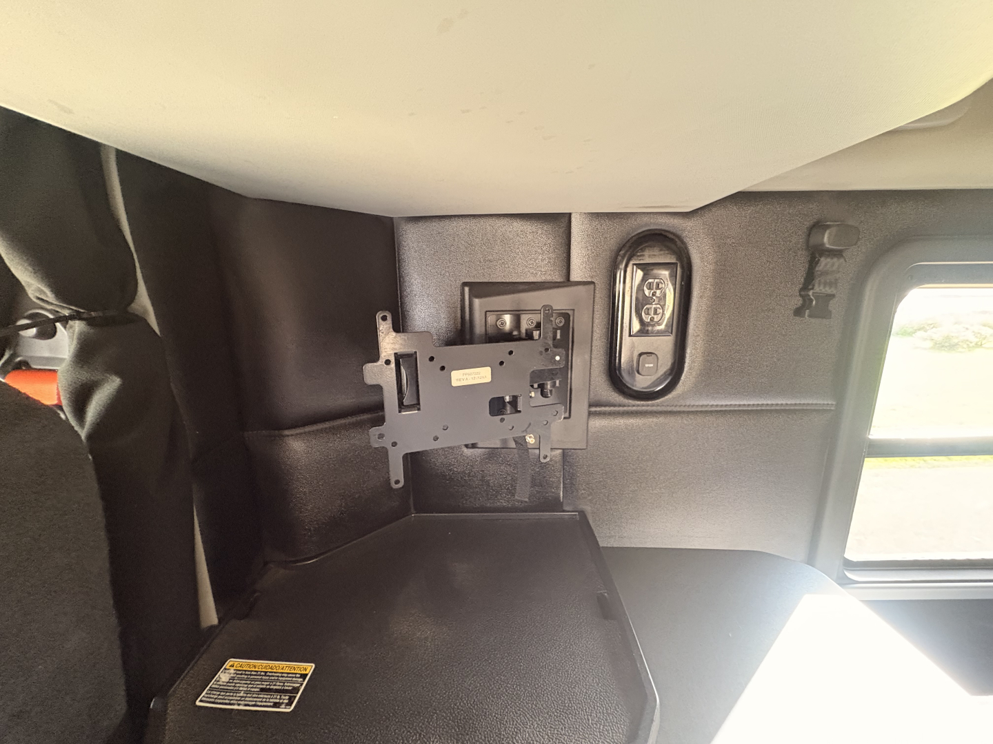 Kenworth T680 cab interior showing mounting bracket and side window; partial view of sleeper area