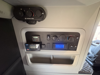 Kenworth T680 interior dash panel showing climate controls stereo and small display with a card in pocket