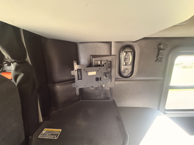 Kenworth T680 cab interior showing mounting bracket and side window; partial view of sleeper area