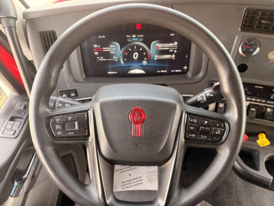 Kenworth T680 steering wheel and instrument cluster with digital dash showing speedometer and gauges.