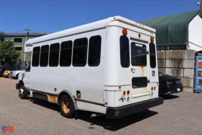 Ford E350 wheelchair bus rear-right view showing back doors and wheelchair accessibility sign.