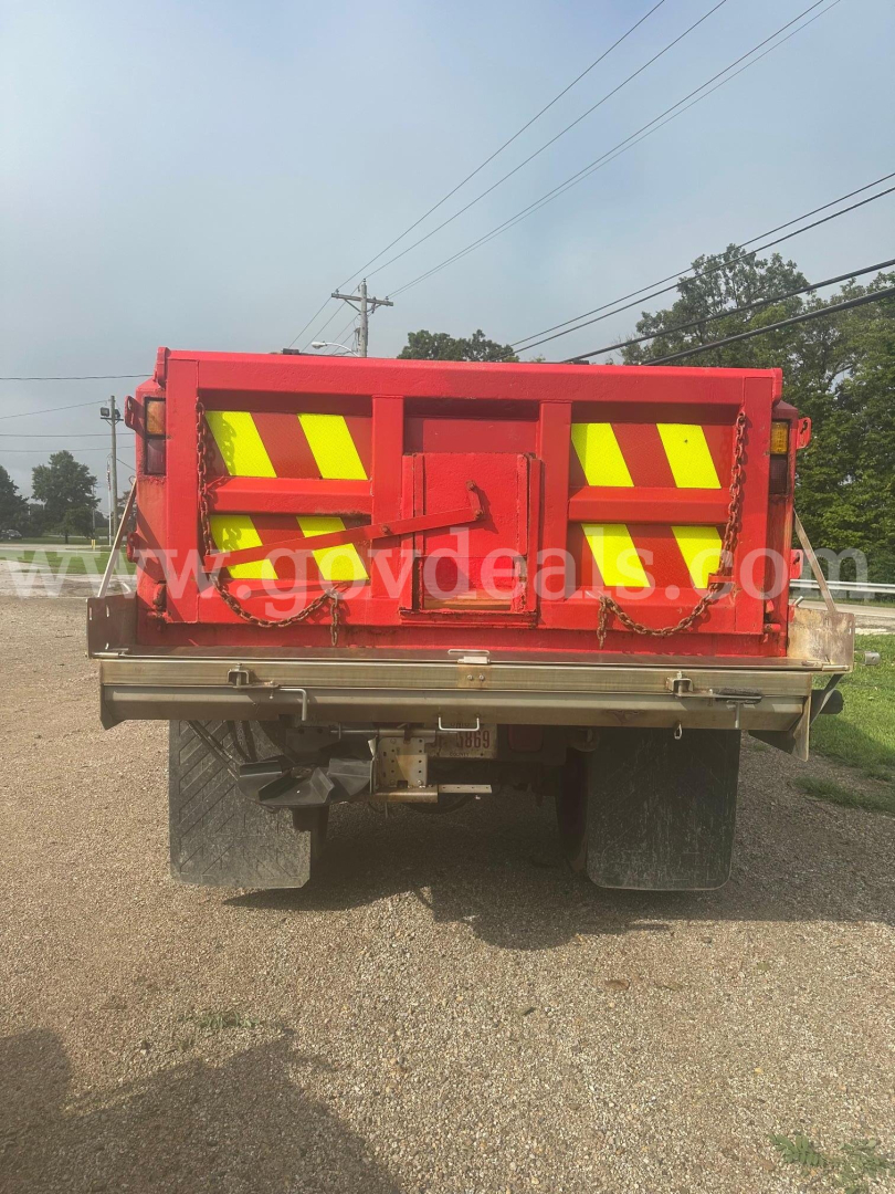 Back view of a red International 7400 plow truck showing reflective chevrons on the tailgate and rear bumper.
