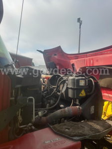 Truck engine bay area of a red 2008 International 7400 with visible hoses and components under the hood.