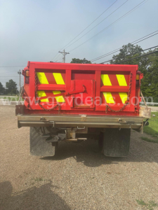 Back view of a red International 7400 plow truck showing reflective chevrons on the tailgate and rear bumper.