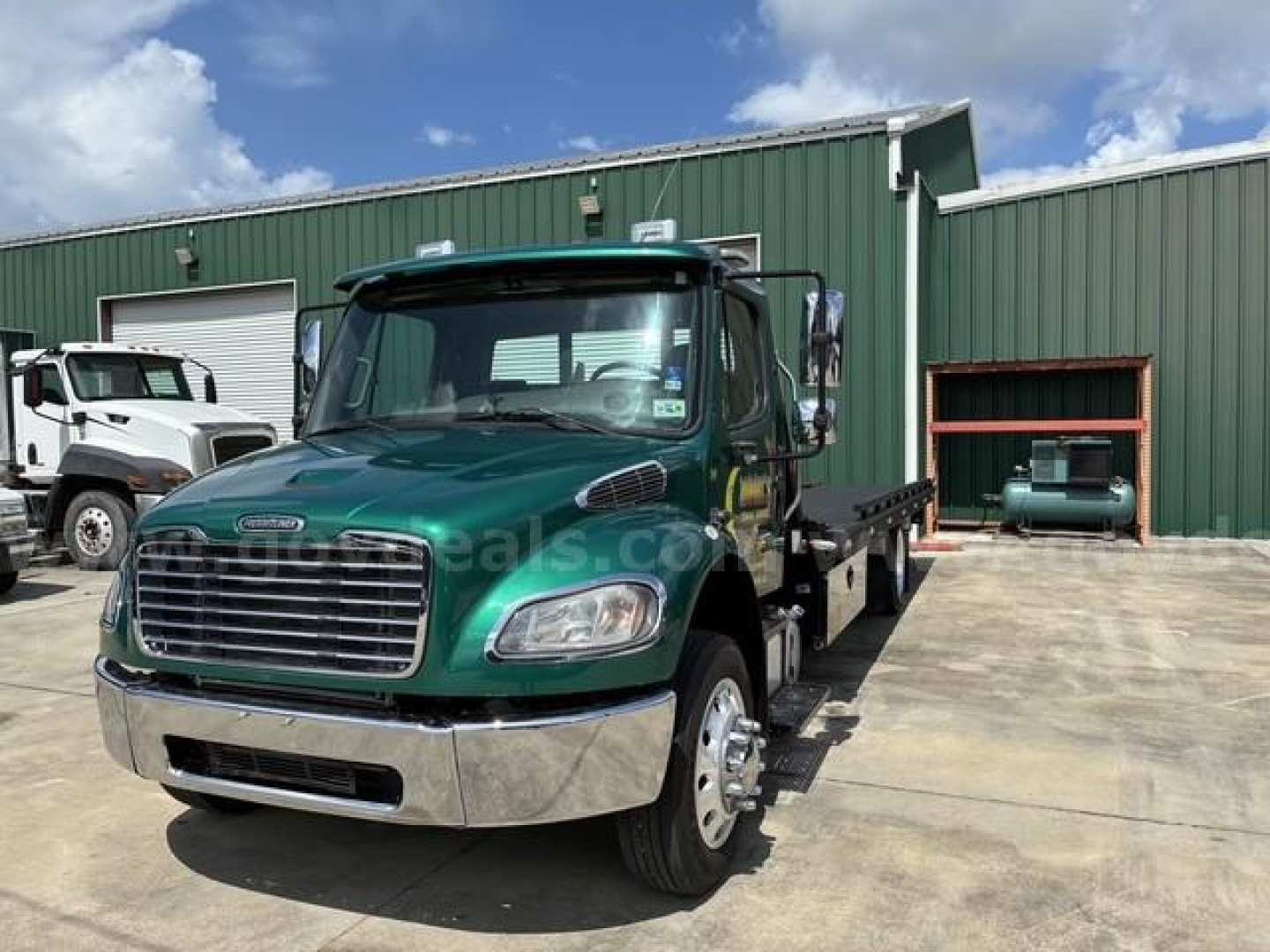 Flatbed tow truck front view of a green 2017 Freightliner M2 106 with chrome bumper and large grille, VIN 1FVACWDT1HHHV4869, stock 22783-201, parked outdoors.