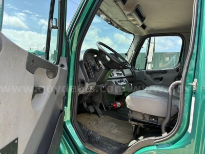 Cab interior of a 2017 Freightliner M2 106 from the driver side showing steering wheel, dashboard, and front seat.