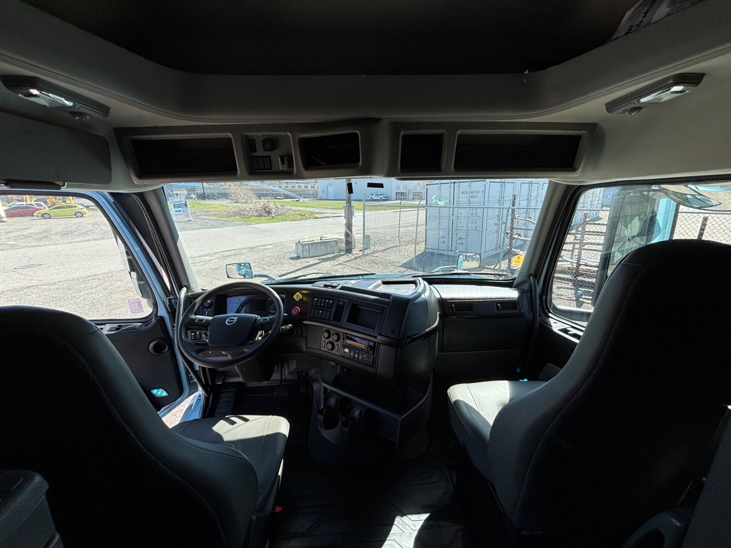 Volvo VNR64T660 truck cabin interior view with steering wheel, dashboard, and front seats.