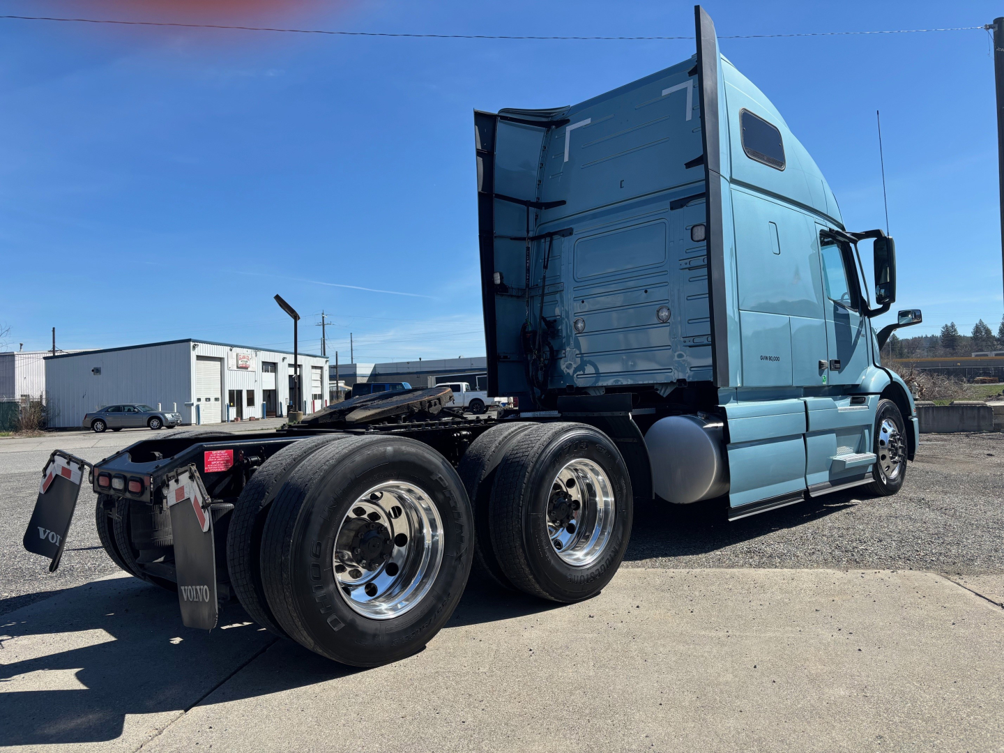 Volvo VNR64T660 sleeper tractor showing rear dual axles and side cab with blue paint.