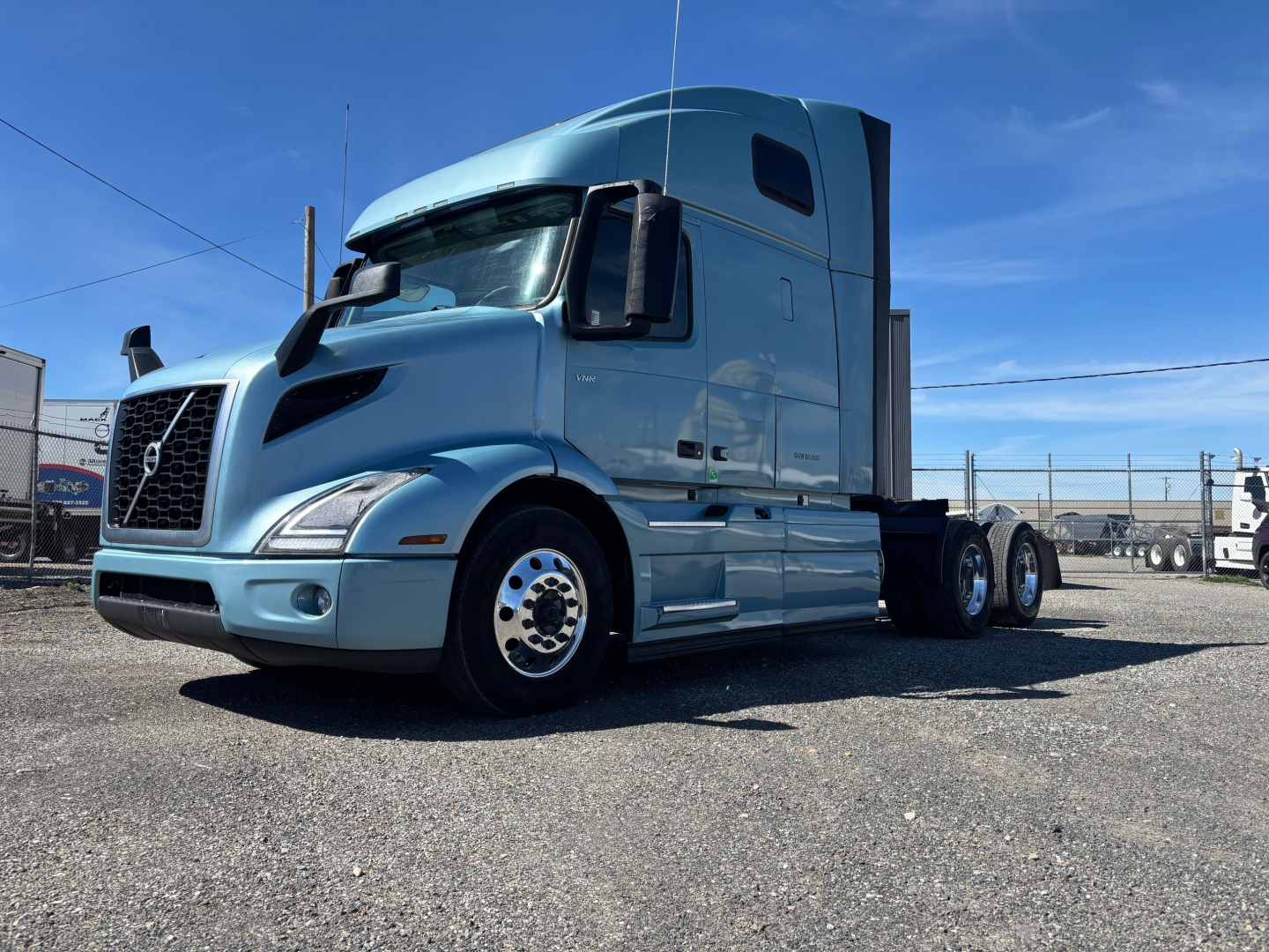 Volvo VNR64T660 sleeper truck in a light blue color, front-left view, with three axles and a high sleeper cab.