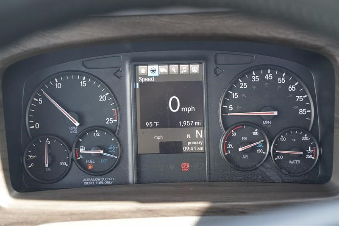 Dashboard cluster of a Western Star truck showing digital display with speed 0 mph and various gauges including fuel, DEF, and oil; center display reads 95F, 1,957 mi, N powertrain; left gauge shows 25 speed tach, right gauges show rpm and