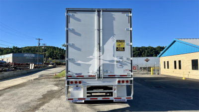 Rear view of a Vanguard globe trailer with double doors and warning sticker, in a lot.