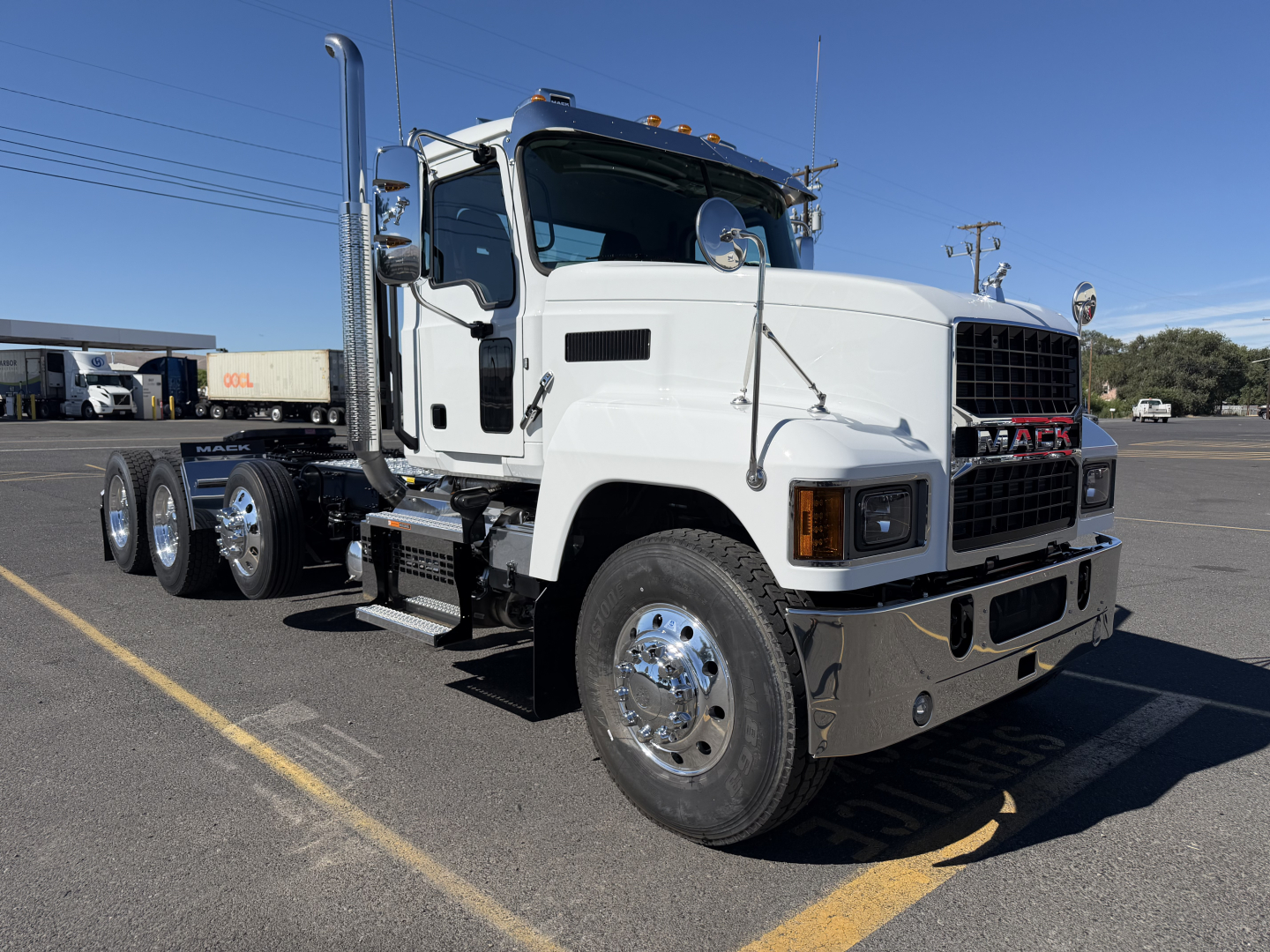 Mack PI84T conventional daycab truck in white, side view showing front grille, chrome bumper, dual rear axles, and fuel/tank areas.