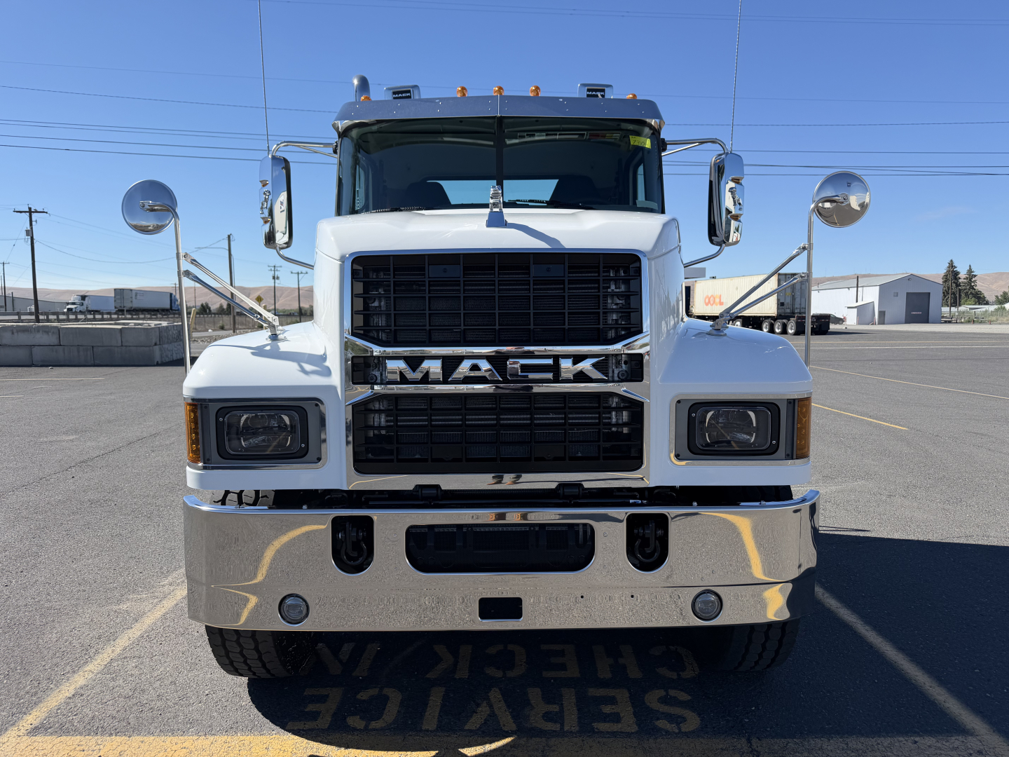 Mack PI84T conventional daycab front view showing large grille with MACK lettering and chrome bumper; headlights and mirrors visible.