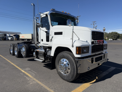 Mack PI84T conventional daycab truck in white, side view showing front grille, chrome bumper, dual rear axles, and fuel/tank areas.