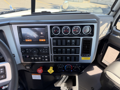 Dashboard of a 2027 Mack PI84T truck showing multiple gauges, infotainment screen, climate controls, and various switches.