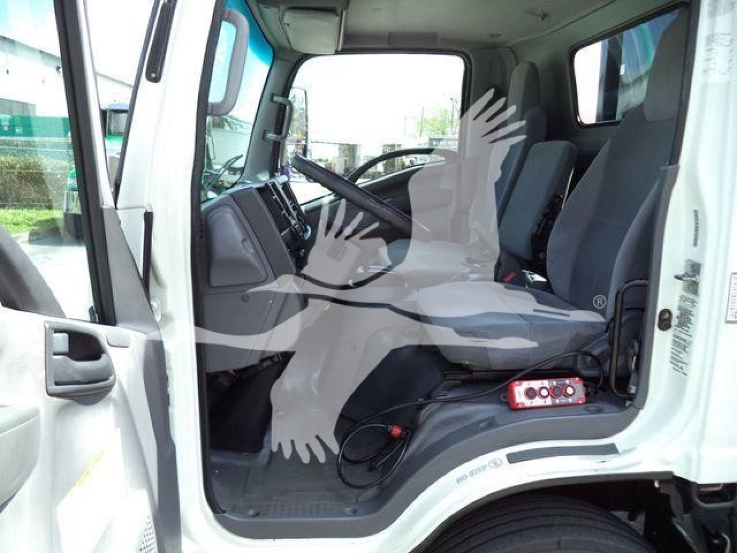Isuzu NRR truck cabin interior view with steering wheel, driver seat, and partial dashboard visible.