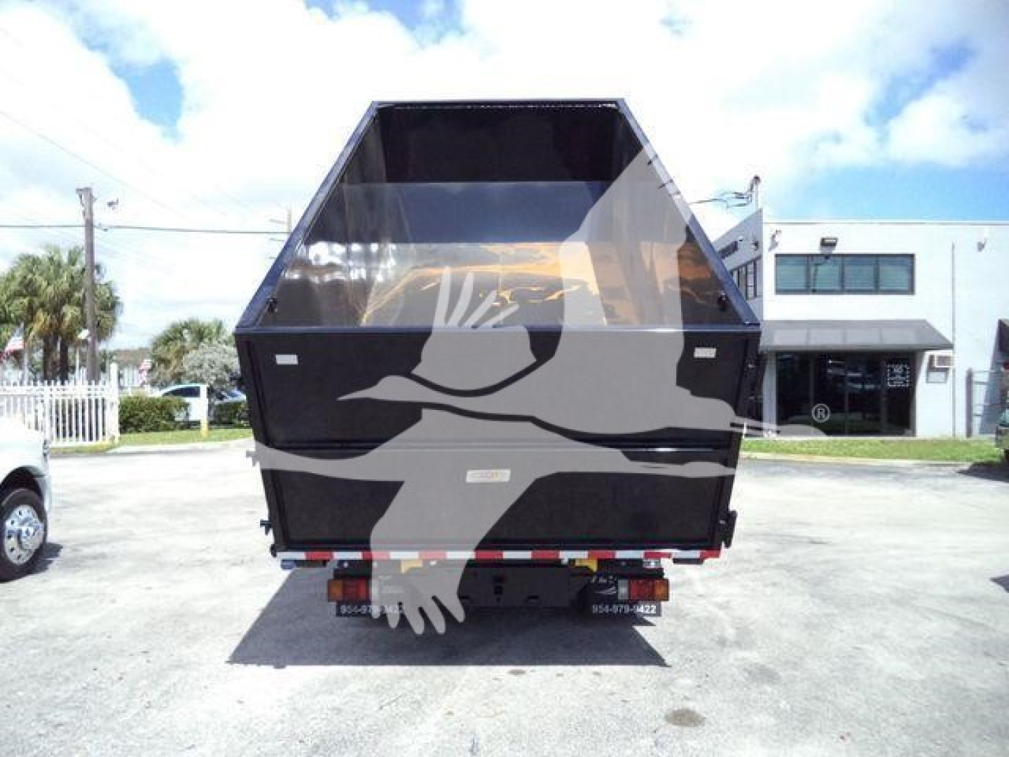 Isuzu NPR/NRR dumping truck bed rear view showing rolloff hopper and tailgate with warning lights.