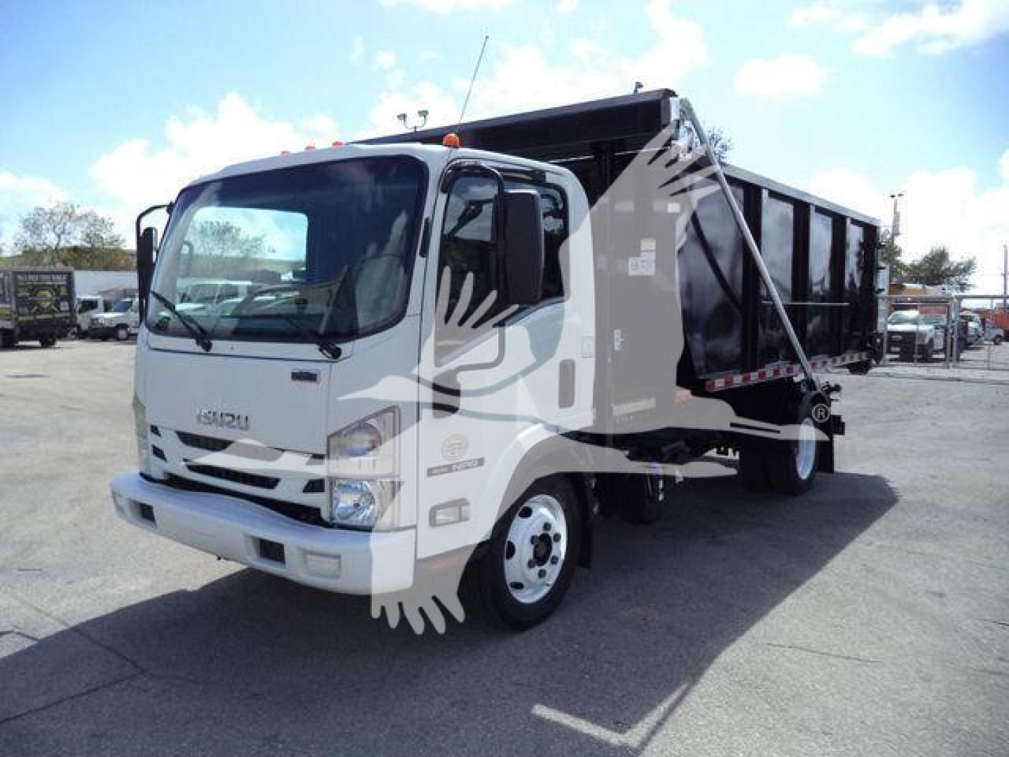 Isuzu NPR-based roll-off truck in-service showing cab and dump bed with latching mechanism and reflective decals.