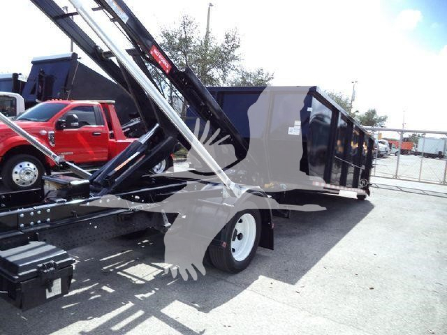 Isuzu NPRR roll-off truck body and crane with dump bed in view.