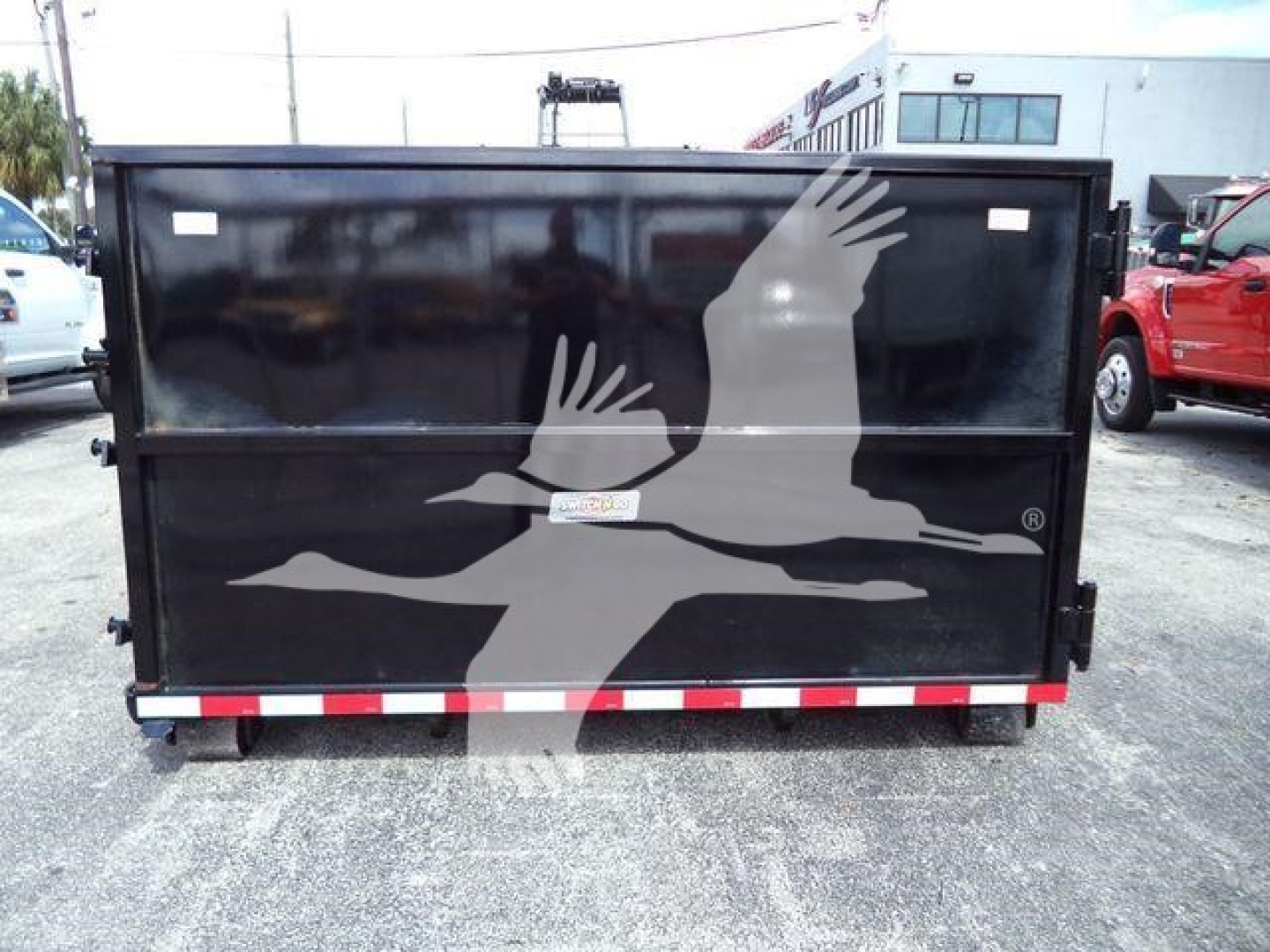 Isuzu NPRR rolloff truck bed back view with black panel and white bird graphic