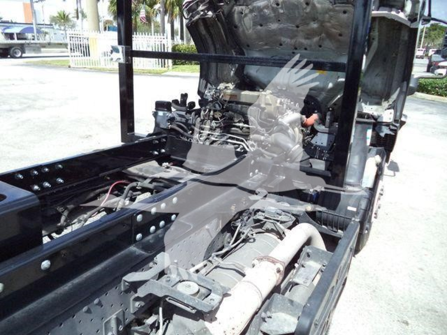 Isuzu NRR truck engine bay with exposed frame and wiring; view of chassis and front cab area.