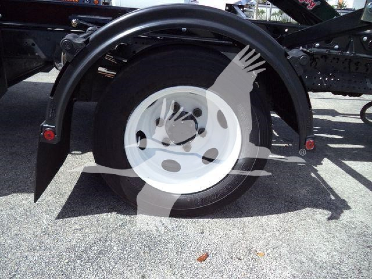 Isuzu NPRRStyle wheel and fender showing white steel rim and tire.