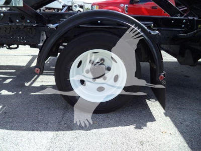 Isuzu NPRR truck rear wheel and suspension view showing white steel wheel, black tire, and chassis framing with fender; load bed not visible.