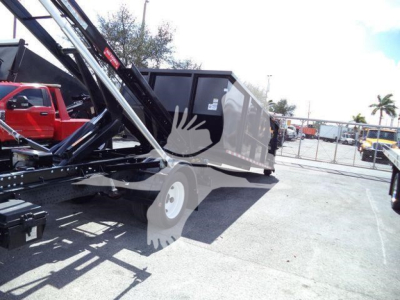Isuzu NPRR roll-off truck in service showing hydraulic lifting mechanism and container bed